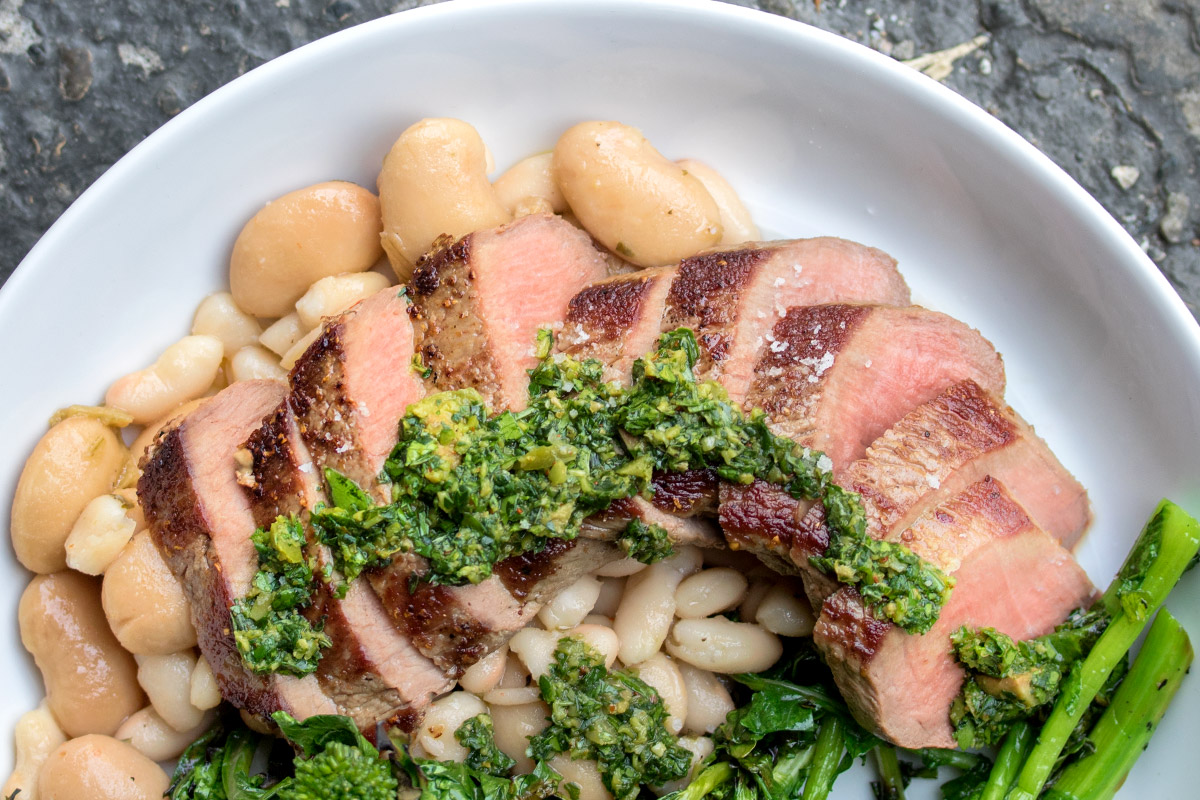SEARED LAMB STRIPLOIN WITH GRILLED RAPINI & MARINATED WHITE BEANS